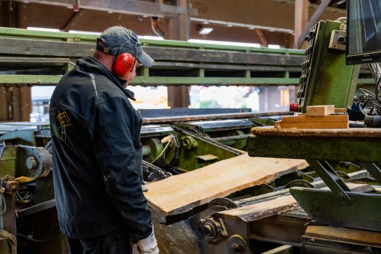 Referenzbild eines Mitarbeiters der Firma Kaulich bei der Weiterverarbeitung der Holzstämme im Sägewerk in Eschwege.