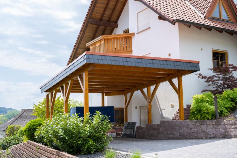 Bild von einem Carport vom Holzbau Kaulich in der Nähe von Eschwege, dass frei an der Seite eines Hauses steht.