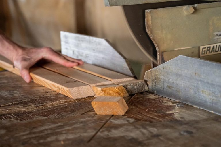 Referenzbild eines Mitarbeiters, der mit einer Maschine das Holz zuschneidet im Sägewerk Kaulich bei Eschwege.